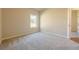 Empty bedroom featuring plush carpet and a large window at 30 Pinewood Dr, Covington, GA 30014