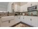Modern kitchen with white cabinets, granite countertops, stainless steel microwave, and farmhouse sink at 30 Pinewood Dr, Covington, GA 30014