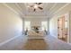 Inviting main bedroom featuring tray ceilings, large windows, soft carpet, and neutral decor at 30 Pinewood Dr, Covington, GA 30014