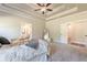 Spacious main bedroom featuring a tray ceiling, ceiling fan, and ensuite bathroom entrance at 30 Pinewood Dr, Covington, GA 30014