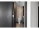 Narrow bathroom with a toilet, storage unit and sink with light herringbone tile at 199 14Th St # 3003, Atlanta, GA 30309