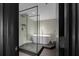 Modern bathroom with glass-enclosed shower, freestanding tub, and tiled walls at 199 14Th St # 3003, Atlanta, GA 30309