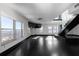 Bright living room featuring hardwood floors, large windows, and modern staircase with glass panels at 199 14Th St # 3003, Atlanta, GA 30309