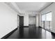 Spacious living room showcasing dark hardwood floors, balcony access, and modern design at 199 14Th St # 3003, Atlanta, GA 30309