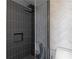 Shower with modern design featuring a glass enclosure, dark tile, and herringbone tile at 199 14Th St # 3003, Atlanta, GA 30309