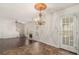 Charming dining room with a decorative chandelier, hardwood floors, and large windows at 6849 Fireside Ln, Atlanta, GA 30349