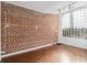 Basement room with hardwood floors, exposed brick, and block windows at 1112 Delaware Se Ave, Atlanta, GA 30316