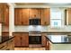 Stylish kitchen featuring stainless steel appliances, dark countertops, wooden cabinets, and a modern backsplash for cooking enjoyment at 106 Henley St, Canton, GA 30114