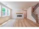 Well-lit living room featuring hardwood floors, a fireplace, large windows, and a staircase, creating a welcoming ambiance at 106 Henley St, Canton, GA 30114