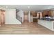 Open-concept living space with hardwood floors, a staircase, and a kitchen featuring an island with a black countertop at 106 Henley St, Canton, GA 30114