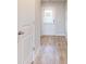 Hallway featuring neutral walls, light wood-look flooring, and an exterior door with window at 1641 Fuma Leaf Way, Mcdonough, GA 30253