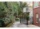 Backyard view with a concrete path, a brick house, lush greenery, and a small elevated deck at 833 E Morningside Ne Dr, Atlanta, GA 30324