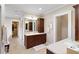 Elegant bathroom with dark wood cabinets, double vanity, walk-in closet, and neutral tile flooring at 833 E Morningside Ne Dr, Atlanta, GA 30324