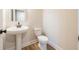 Powder room featuring a pedestal sink, toilet, and wood flooring at 138 Henley St, Canton, GA 30114