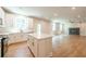 Modern kitchen featuring white cabinets, hardwood floors, and a center island overlooking the living area at 138 Henley St, Canton, GA 30114