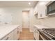 Bright kitchen featuring white cabinets, stainless steel appliances, and wood flooring at 138 Henley St, Canton, GA 30114