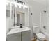 Well-lit bathroom with gray vanity, tile shower, and modern fixtures at 708 Martin Rd, Stone Mountain, GA 30088