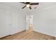 Bedroom with wood floors, ceiling fan, closet, and an open doorway at 708 Martin Rd, Stone Mountain, GA 30088