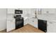 Modern kitchen featuring white cabinets, sleek black appliances, and beautiful quartz countertops at 708 Martin Rd, Stone Mountain, GA 30088