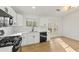 Bright kitchen featuring white cabinets, quartz countertops, black hardware, modern appliances, and french doors at 708 Martin Rd, Stone Mountain, GA 30088