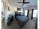 Bedroom with a dark bed set, modern decor, desk, ceiling fan, and natural light at 5257 Shorthorn Way, Powder Springs, GA 30127
