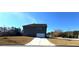Home exterior showcasing a two-car garage, long driveway, and expansive lawn at 5257 Shorthorn Way, Powder Springs, GA 30127