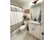 Stylish bathroom with a granite countertop, framed floral art, and a shower featuring a gray-striped curtain at 91 Morris Brown Sw Dr, Atlanta, GA 30314