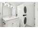 Bathroom features a modern vanity with a stacked washer/dryer unit at 5400 Roswell Rd # C3, Atlanta, GA 30342