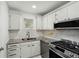 This kitchen features stainless steel appliances, white cabinets, a double sink, and granite countertops at 5400 Roswell Rd # C3, Atlanta, GA 30342