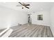 Sunlit living room boasts stylish flooring, a ceiling fan, and a practical kitchen serving hatch at 5400 Roswell Rd # C3, Atlanta, GA 30342