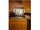 Cozy kitchen featuring wooden cabinets, a double sink, and a window overlooking the backyard at 359 Cornish Mtn Rd, Oxford, GA 30054