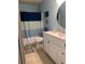 Bathroom with blue color scheme, white vanity, round mirror, and blue and white shower curtain at 2705 Greystone Pl, Austell, GA 30106