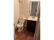 This is a bathroom with a standard toilet and a sink with brown cabinets at 2705 Greystone Pl, Austell, GA 30106