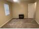Bedroom with window and neutral carpet, a small black nightstand beside a white door, and cream walls at 2705 Greystone Pl, Austell, GA 30106