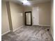 Cozy bedroom featuring gray carpet, neutral walls, a dark-wood framed full-length mirror, and a white door at 2705 Greystone Pl, Austell, GA 30106