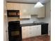 Functional kitchen with black appliances, white cabinetry, and a convenient layout at 2705 Greystone Pl, Austell, GA 30106