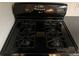 A black gas stove with four burners and a digital display for precise cooking at 2705 Greystone Pl, Austell, GA 30106