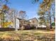 Backyard view of a two-story home featuring a deck, lawn, and trees under a blue sky in autumn at 370 Charlyne Way, Dacula, GA 30019