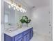 Bright bathroom featuring a blue vanity with marble countertop and a large mirror with stylish lighting at 370 Charlyne Way, Dacula, GA 30019