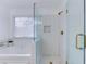 Updated bathroom showcasing a glass-enclosed shower with herringbone tile and gold fixtures, alongside a soaking tub at 370 Charlyne Way, Dacula, GA 30019