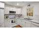 Bright kitchen featuring white cabinets, tiled backsplash, and modern appliances at 370 Charlyne Way, Dacula, GA 30019