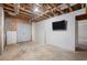 Unfinished basement space with exposed beams and a TV on the wall at 2612 Grove Park Ln, Conyers, GA 30094