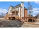 Rear elevation features upper and lower decks, a fireplace chimney, and a lawn at 2612 Grove Park Ln, Conyers, GA 30094