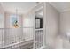 Bright hallway with wood floors, white banister, and natural light streaming through a window at 2612 Grove Park Ln, Conyers, GA 30094