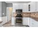 Modern kitchen with stainless steel appliances, granite countertops, and luxury vinyl plank flooring at 2612 Grove Park Ln, Conyers, GA 30094