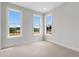 A bright bedroom with three windows features neutral carpet and freshly painted walls at 822 Urban Grange Way, Suwanee, GA 30024