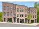 Stylish brick townhomes with dark-framed windows, blue doors, and manicured landscaping at 822 Urban Grange Way, Suwanee, GA 30024