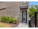 Close up of a blue front door on a brick townhome with green shrubbery and a dark awning at 822 Urban Grange Way, Suwanee, GA 30024