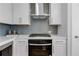 Close up of a modern kitchen with white cabinets, stainless steel appliances, and gray backsplash at 822 Urban Grange Way, Suwanee, GA 30024