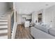 Open-concept living area with hardwood floors, modern decor, and staircase on the left at 822 Urban Grange Way, Suwanee, GA 30024